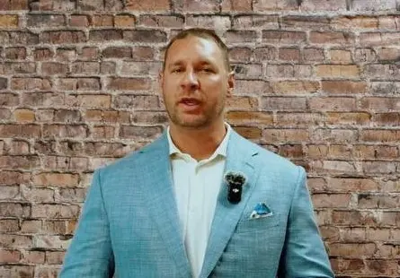 Robert Sears speaking in front of a brick wall
